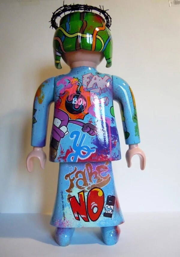Playmobil bleu ciel, graffé avec une couronne en fil de fer barbelé