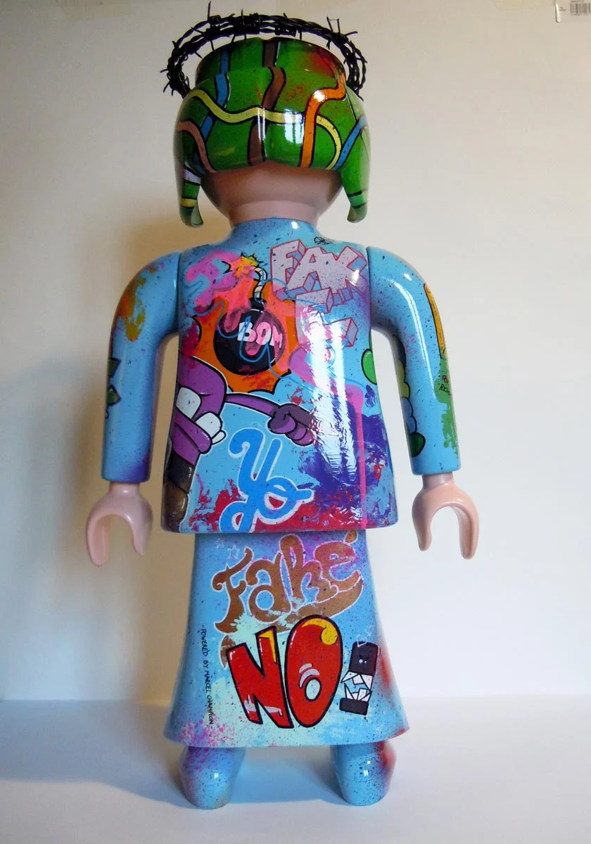 Playmobil bleu ciel, graffé avec une couronne en fil de fer barbelé