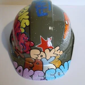Casque vert armée, graffé avec accumulation de tag Fake de différentes couleurs