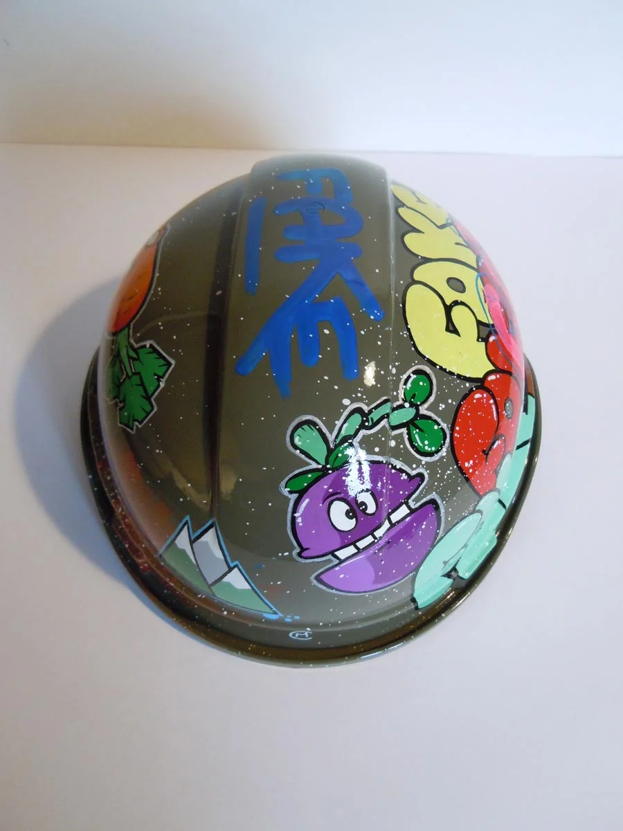 Casque vert armée, graffé avec accumulation de tag Fake de différentes couleurs