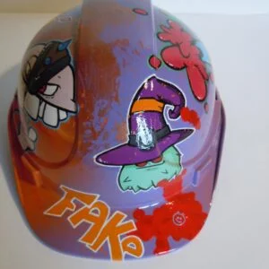 Casque violet clair et bronze avec lettrage FAKE peint dessus