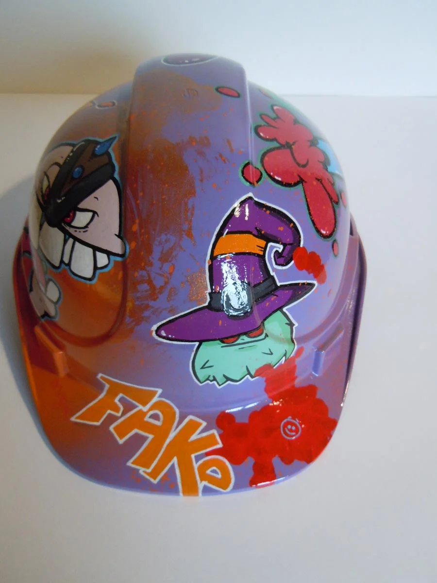 Casque violet clair et bronze avec lettrage FAKE peint dessus