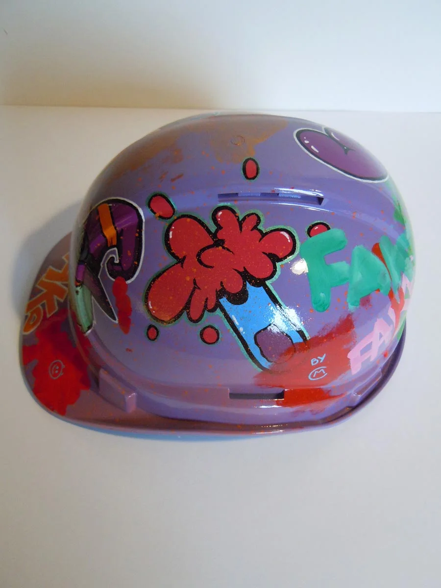 Casque violet clair et bronze avec lettrage FAKE peint dessus