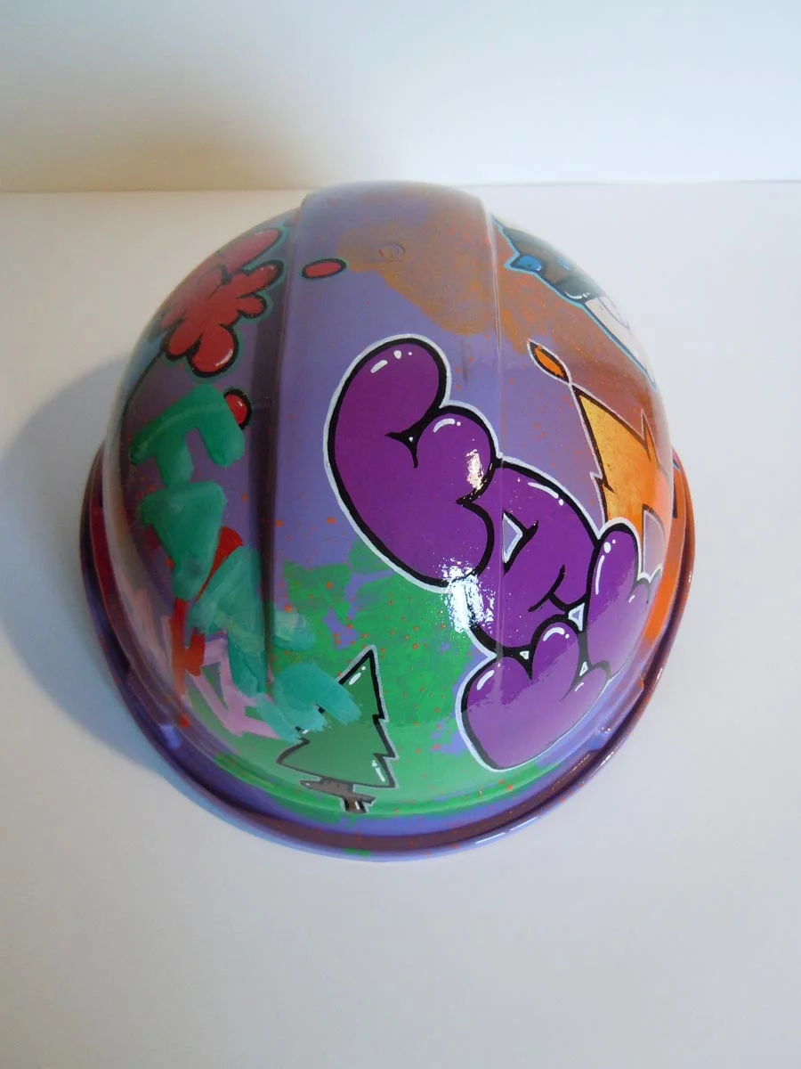 Casque violet clair et bronze avec lettrage FAKE peint dessus