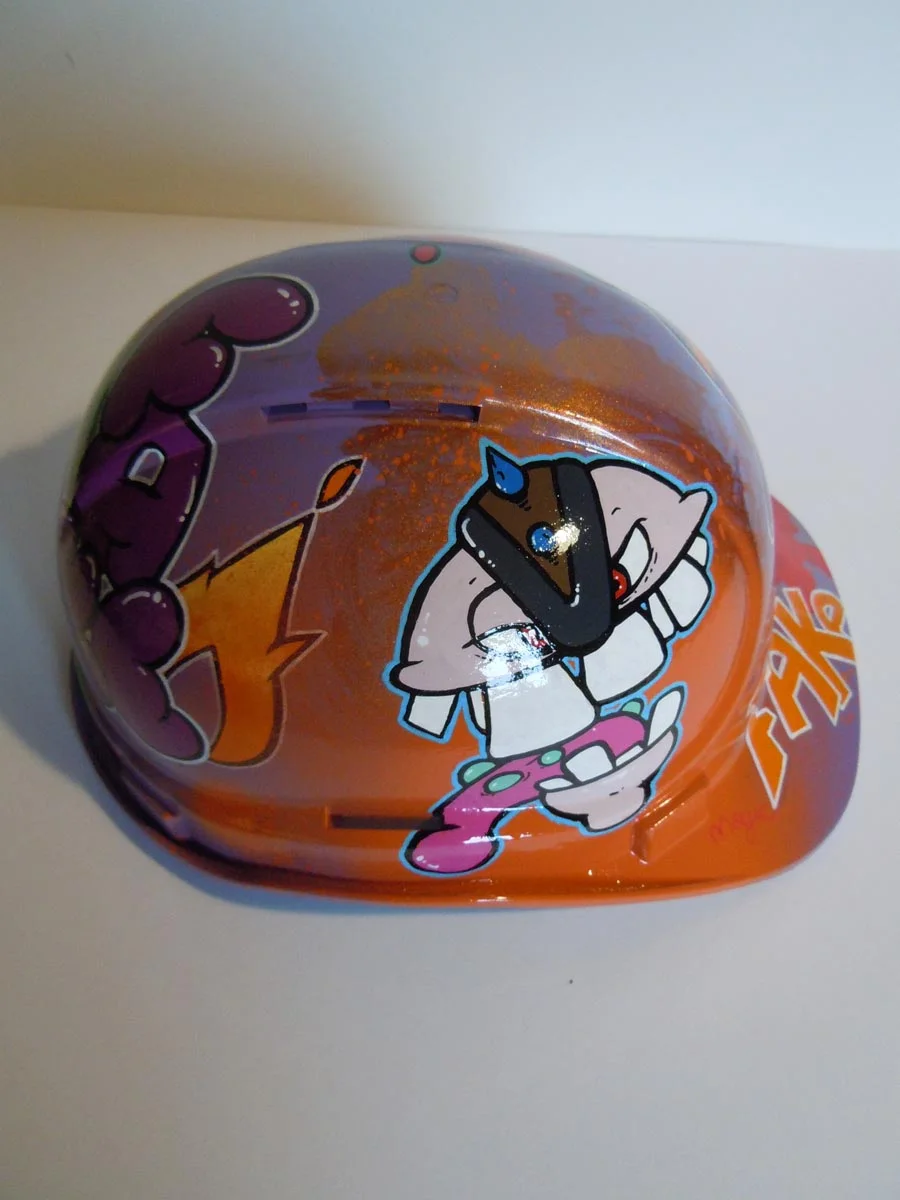 Casque violet clair et bronze avec lettrage FAKE peint dessus