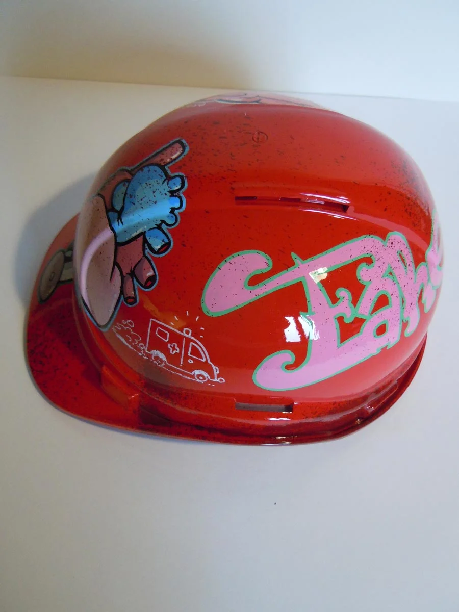 Casque rouge vif, graffé, avec des organes peints dessus (coeur, cerveau etc...).