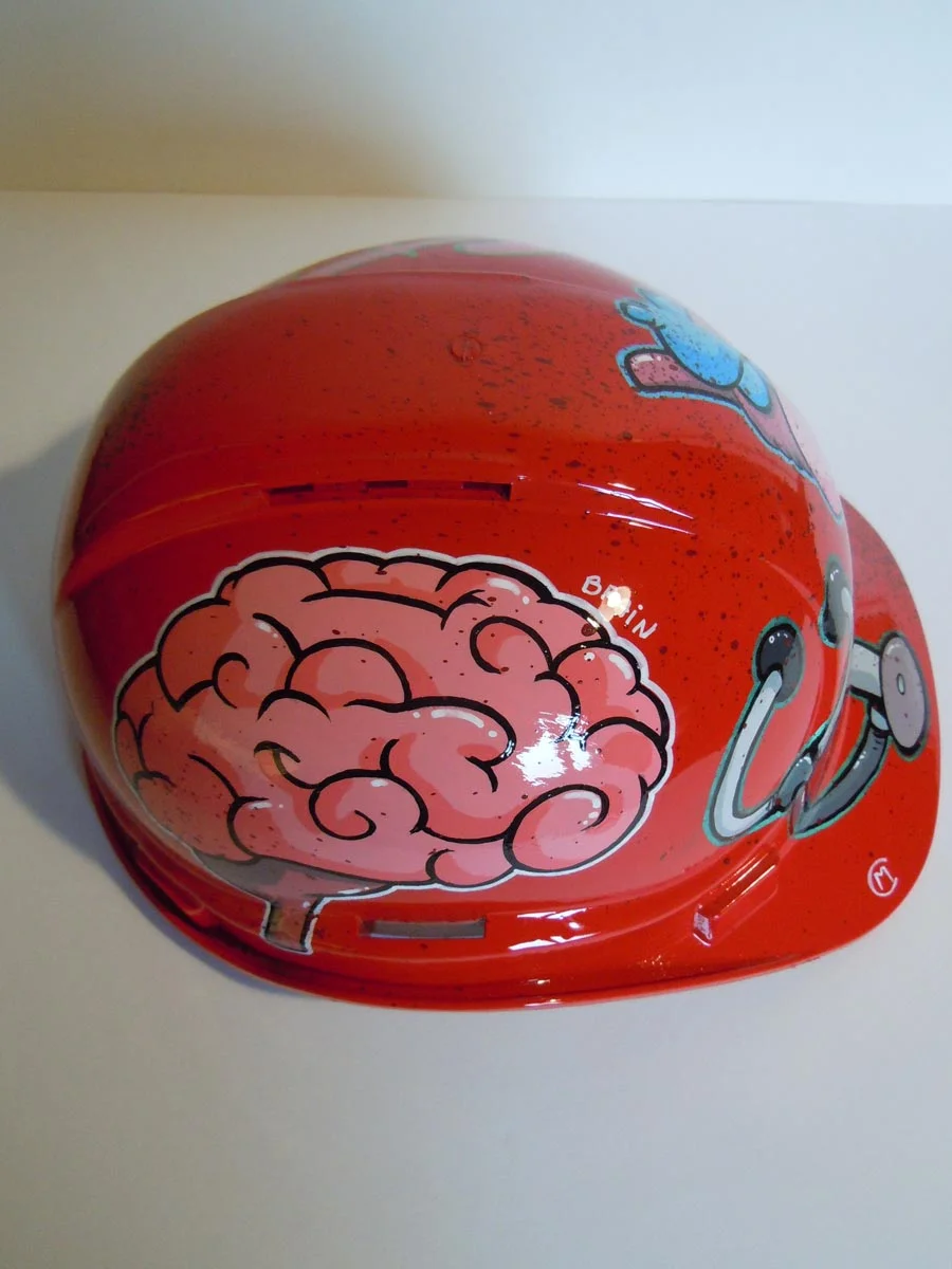 Casque rouge vif, graffé, avec des organes peints dessus (coeur, cerveau etc...).