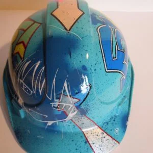 Casque bleu clair, graffé, avec un personnage manga sur le devant.