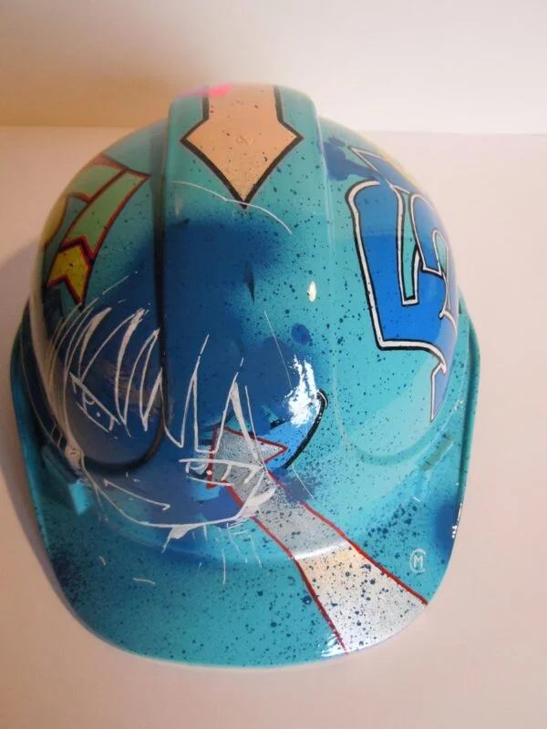 Casque bleu clair, graffé, avec un personnage manga sur le devant.