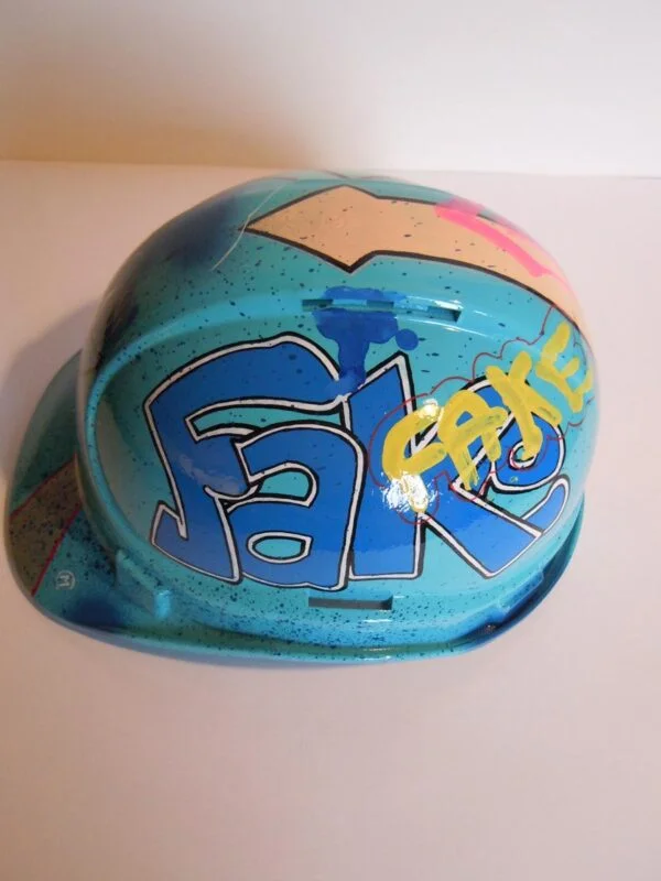 Casque bleu clair, graffé, avec un personnage manga sur le devant.