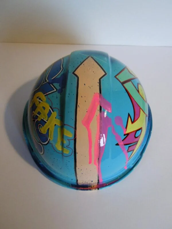 Casque bleu clair, graffé, avec un personnage manga sur le devant.