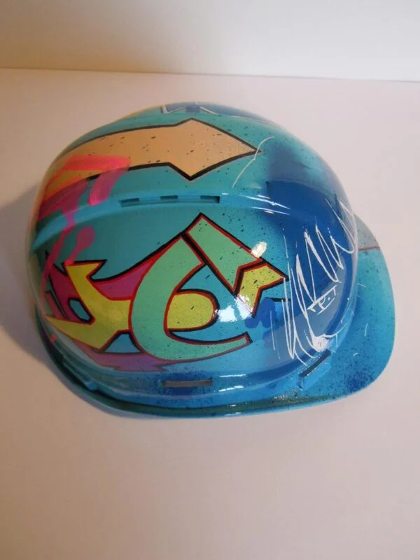 Casque bleu clair, graffé, avec un personnage manga sur le devant.