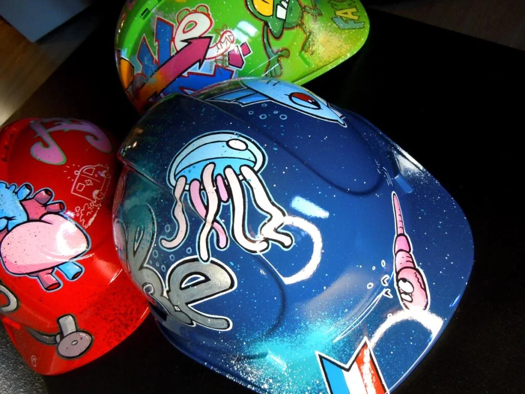 trois casques graffés par Fake, la branche street art de Marcel Champion