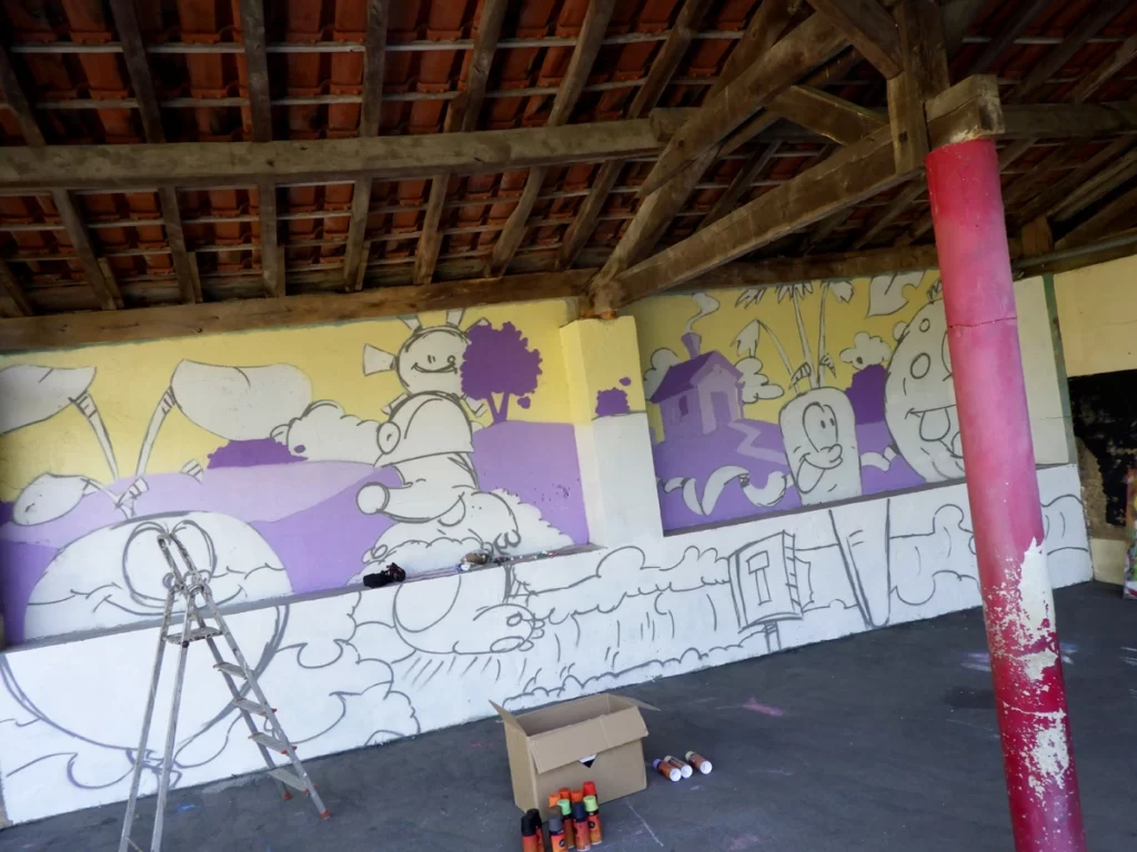 Photo illustrant la seconde étape d'un graffiti, la mise en couleur. Ici, le ciel et les arrières plans sont déjà en place.