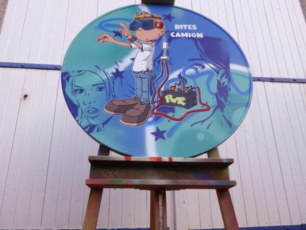 Vue en contre plongée du panneau. Il est posé sur un chevalet de peintre. On voit sur le chevalet les stigmates de peintures.