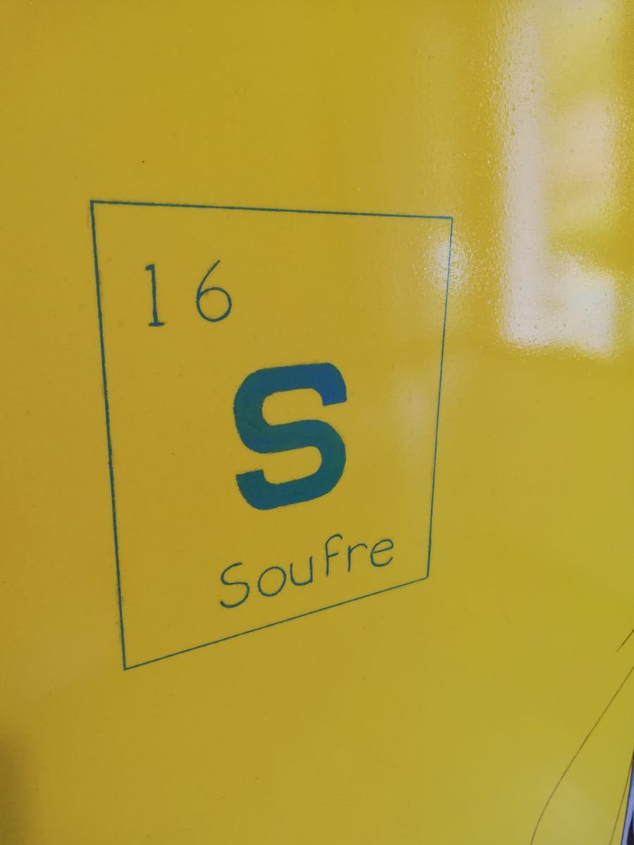 Vue en gros plan du carré représentant l'élément soufre. On y retrouve le S qui symbolise le soufre ainsi que son numéro atomique.