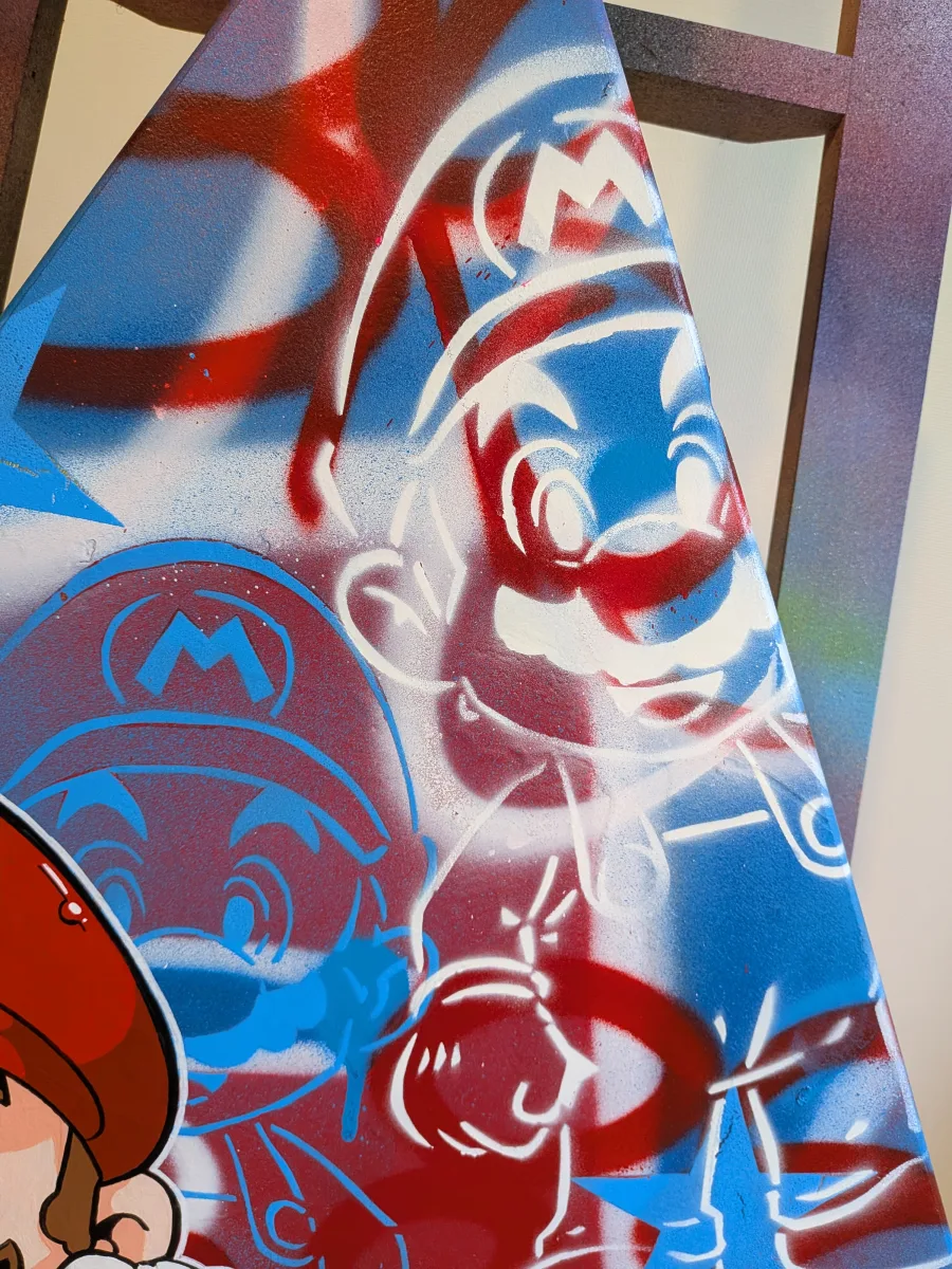 Gros plan sur les pochoirs représentant Mario. Il y en a un blanc et l'autre bleu.