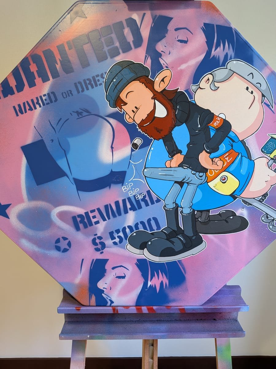 Plan rapproché sur le panneau peint aux couleurs des inspecteurs Lapince et Domino. On voit très bien les détails sur les personnages et le traitement graphique très différent entre le fond et le premier plan. Un liseret blanc vient encore aidé à détacher les personnage du fond, un peu comme si on avait collé un sticker sur le panneau stop.