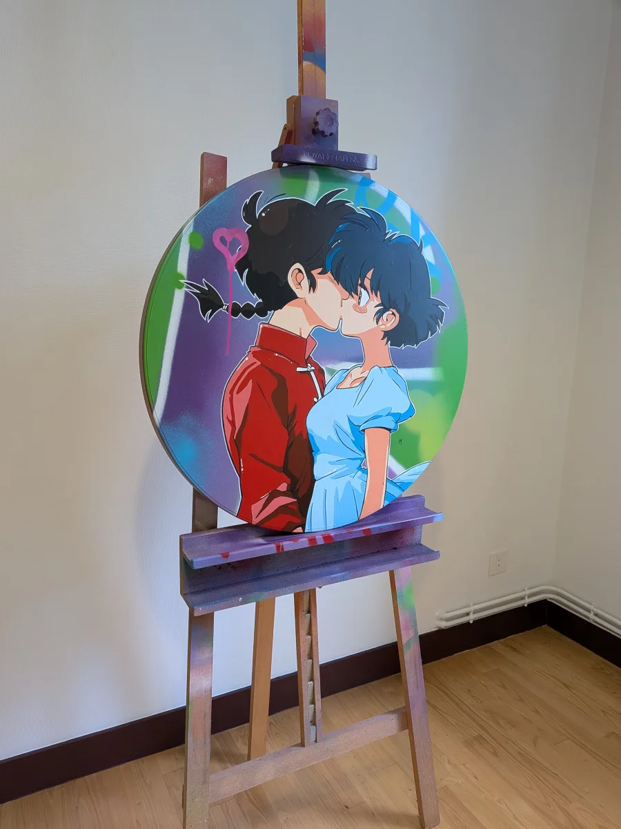 Cette image montre une peinture originale exécutée sur un vrai panneau de signalisation routière circulaire (diamètre classique de 60 cm), détournée en œuvre d’art unique.Ranma et Akane s’embrassent avec tendresse sur un fond street-art explosif violet-vert-bleu, rehaussé d’un cœur rose fluo qui dégouline avec malice. Pour un acheteur, l’intérêt décoratif est immédiat : pièce forte et ultra-pop qui mixe nostalgie manga 90’s, énergie urbaine et humour graffiti. Son format rond, son éclat métallique d’origine et ses couleurs saturées en font un véritable statement piece, parfait pour dynamiser un salon, une chambre d’ado ou un espace créatif. C’est à la fois un clin d’œil affectueux à Ranma ½ et une œuvre contemporaine signée qui ne passe jamais inaperçue – un fragment de rue devenu icône romantique à accrocher au mur !