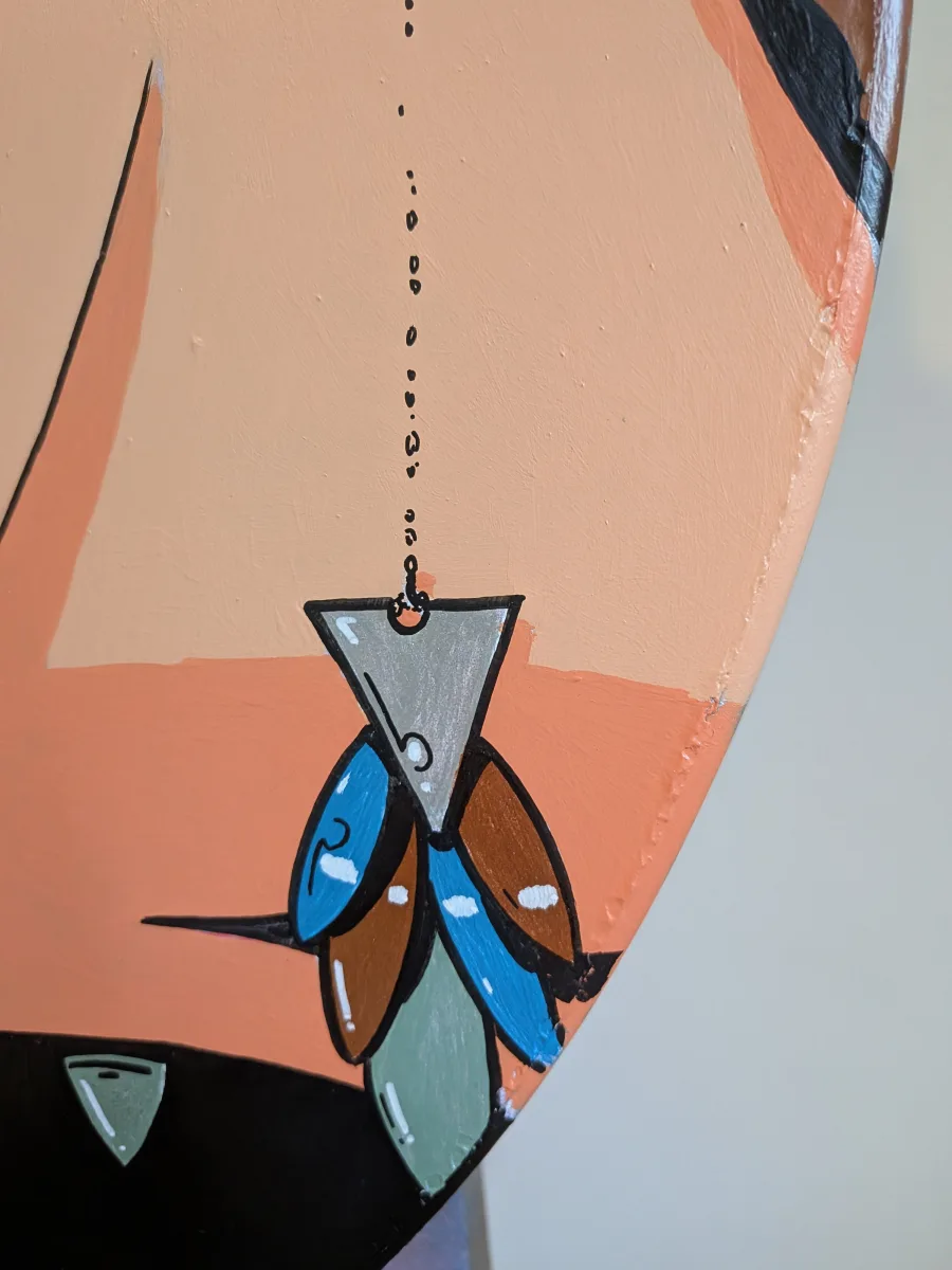 Gros plan sur le pendentif de Dorothy Black. pendentif traité avec des peintures métalliques pour ajouter au raffinement de la peinture.