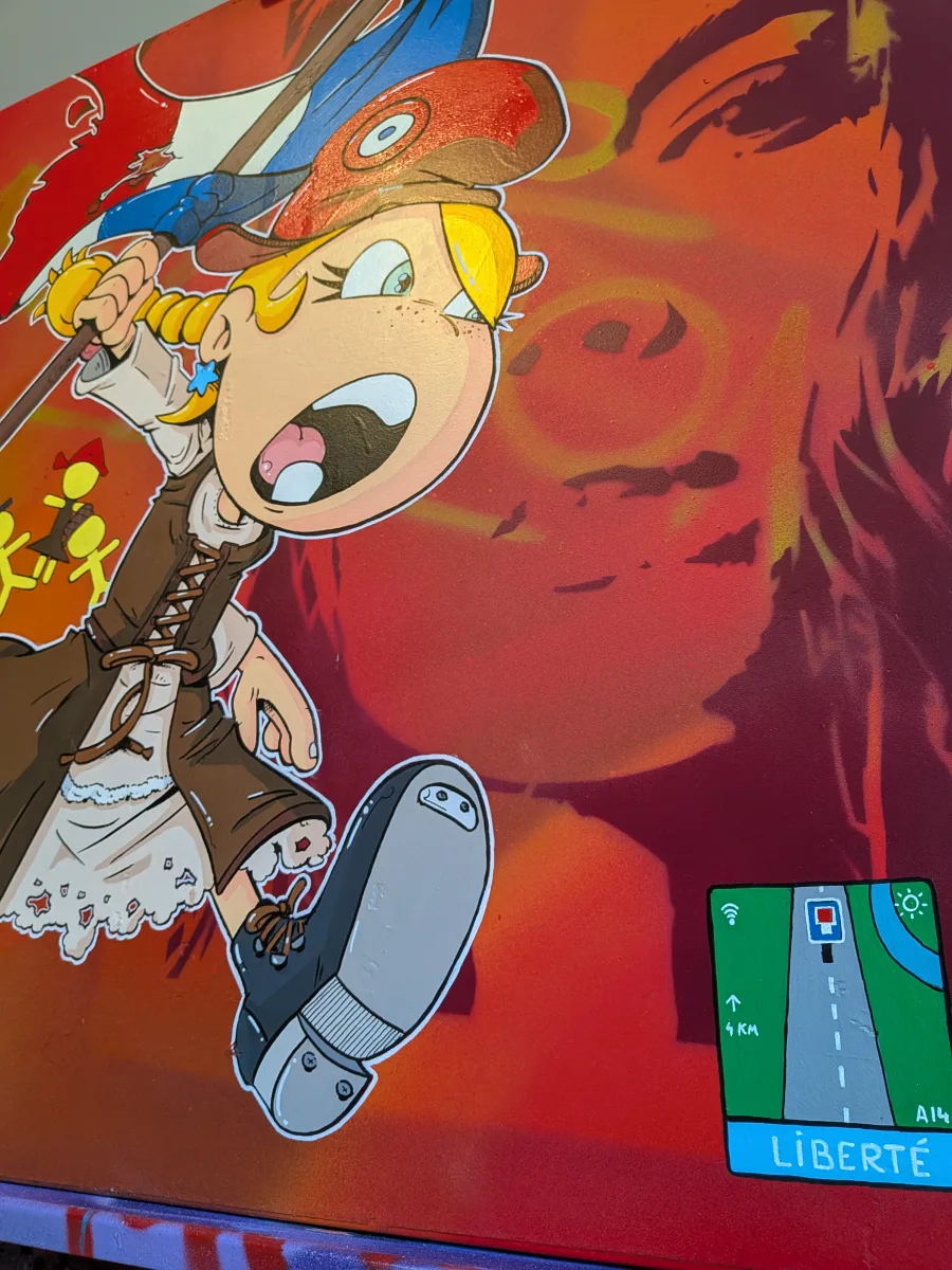 Détail explosif de l’œuvre sur panneau signalétique : Thérébentine, l’héroïne culte de la BD, fonce littéralement dans le tableau, sa grosse chaussure de gavroche en avant comme si elle allait écraser le spectateur. Derrière elle, le visage géant de Marianne (inspiré de Delacroix) se dessine en ombre rouge, tandis qu’un faux GPS autoroutier indique ironiquement « LIBERTÉ – 4 km – A14 ». Énergie brute, couleurs saturées et humour rebelle : un concentré d’art urbain contemporain qui détourne à la fois la grande histoire et la signalisation routière. Thérébentine chaussure détail, Thérébentine écrasant le tableau, street art panneau routier Liberté 4 km, Delacroix Marianne BD, art urbain français engagé, peinture contemporaine Thérébentine 2025, pop art révolutionnaire signalisation