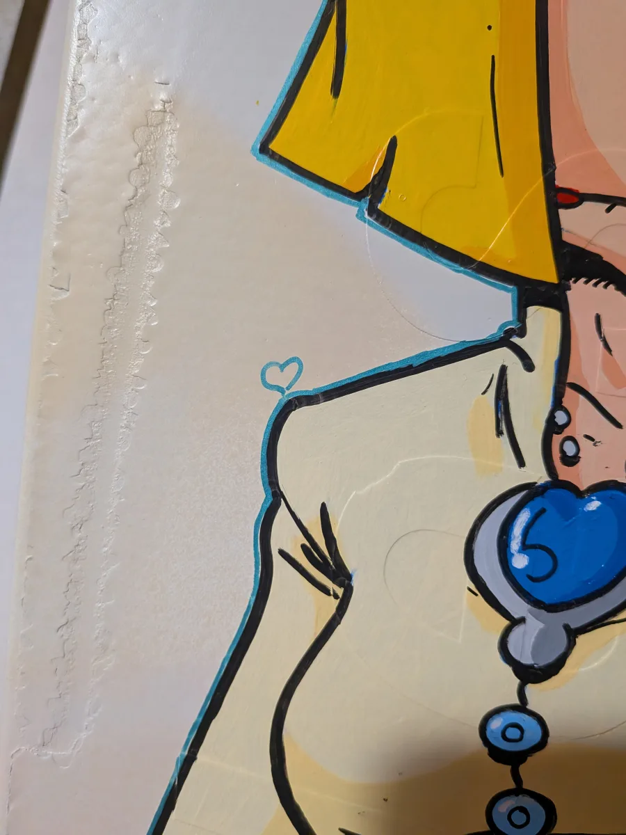 Gros plan sur un détail du contour du personnage de Circé. Un liseret métallique couleur bleue entoure le personnage de Circé et au coin de l'épaule du personnage on aperçoit un coeur.