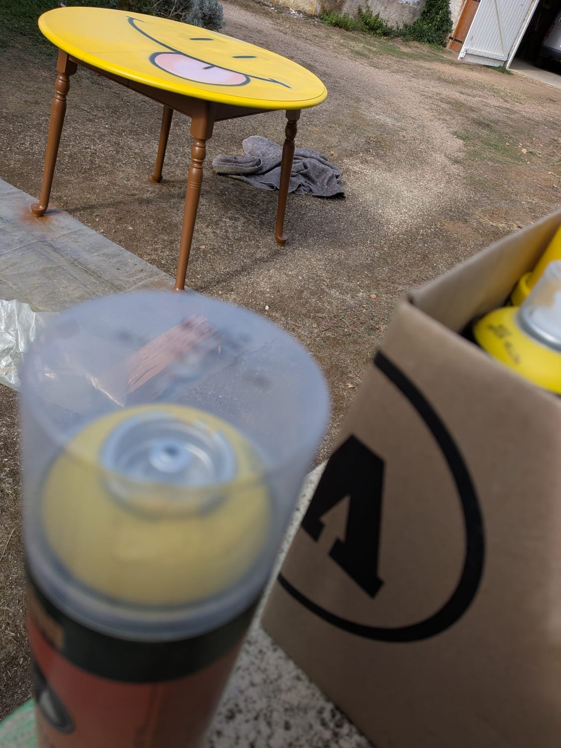 Making of de la réalisation de la table smiley, on voit que le plateau vient d'être peint à la bombe de peinture.
