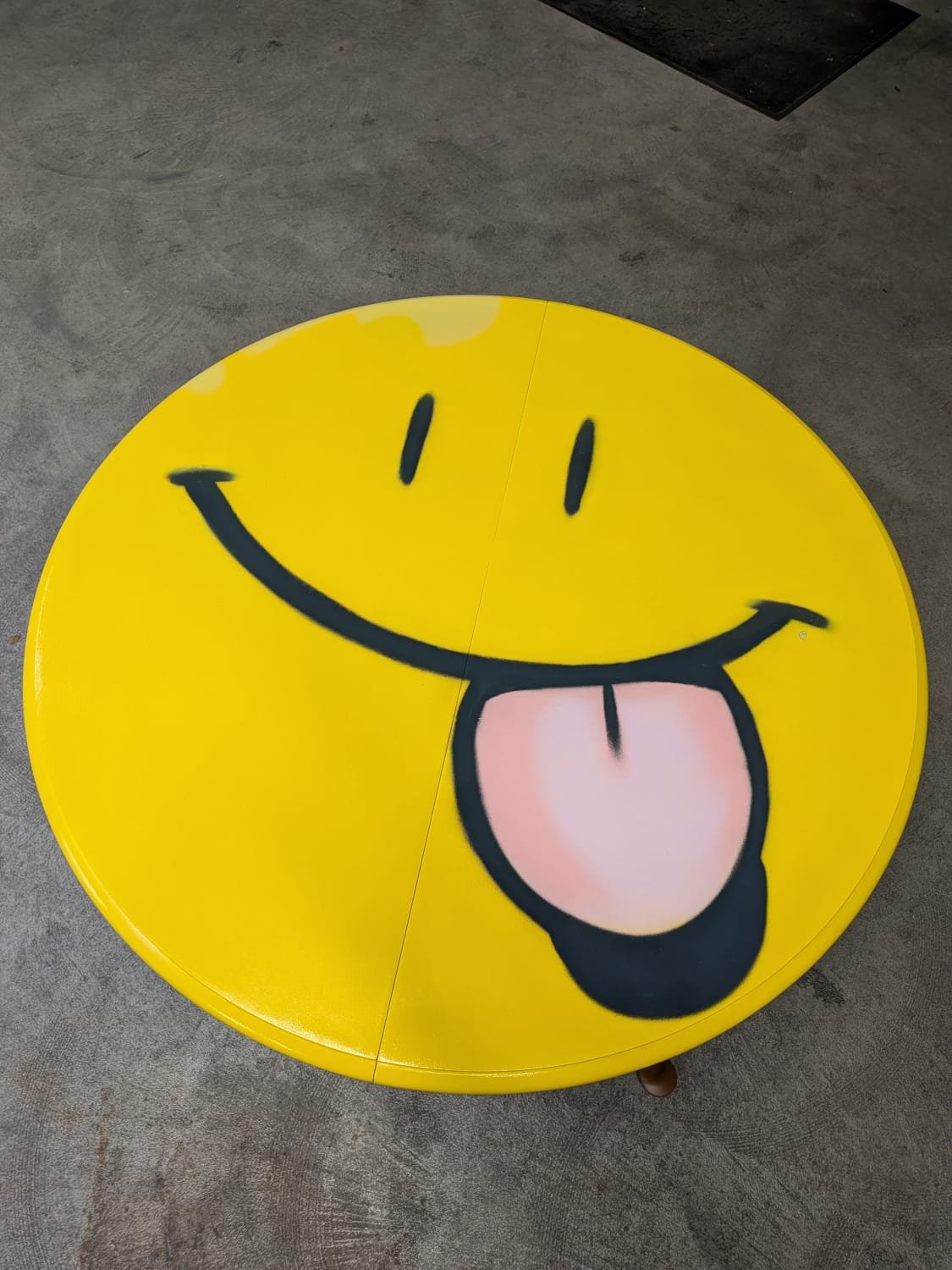 Le plateau de la table en jaune vif ressemble sur cette photo à un badge.
