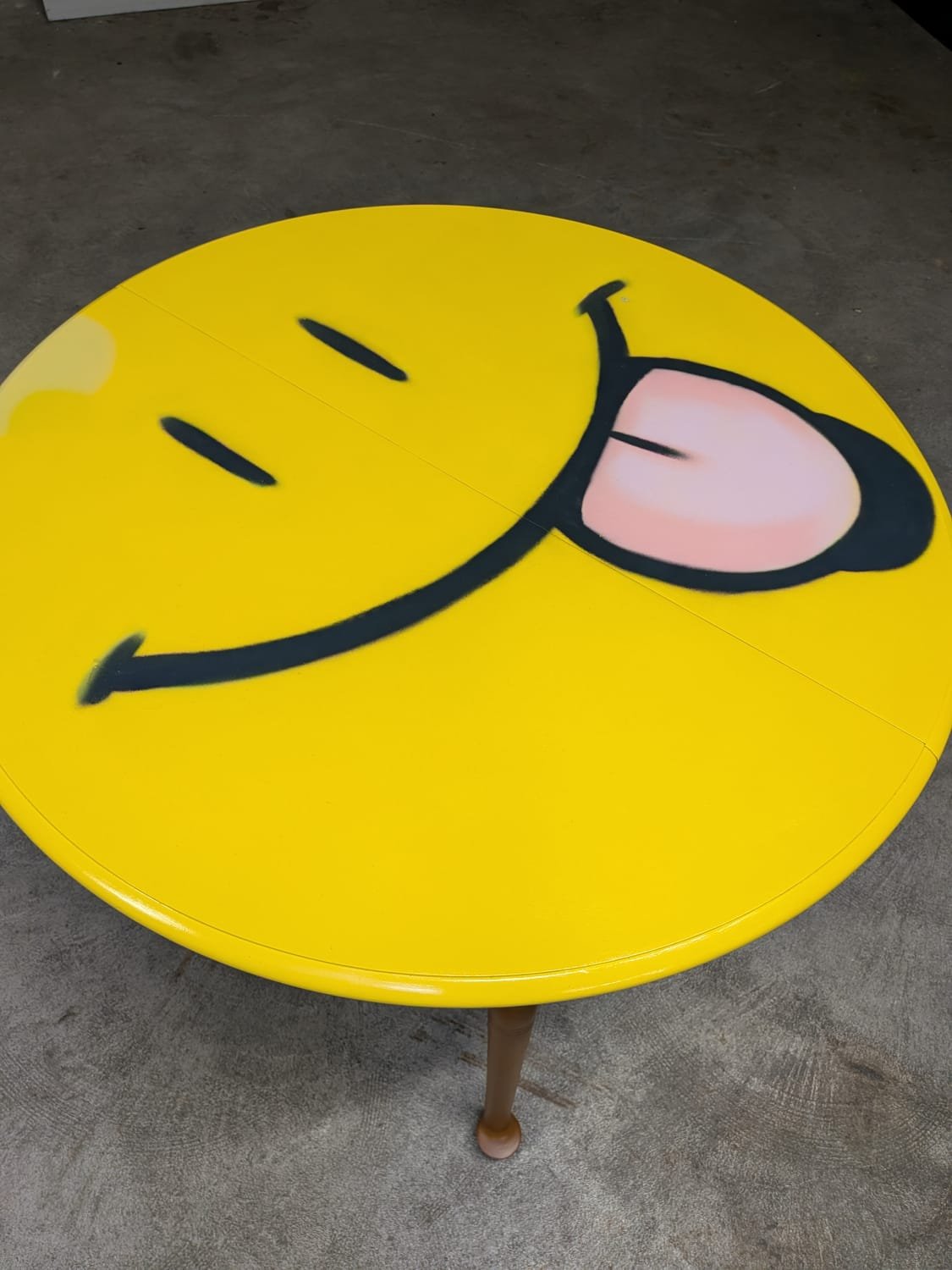 Vue du plateau de la table smiley. On voit très bien le plateau avec le smiley qui sourit peint dessus.