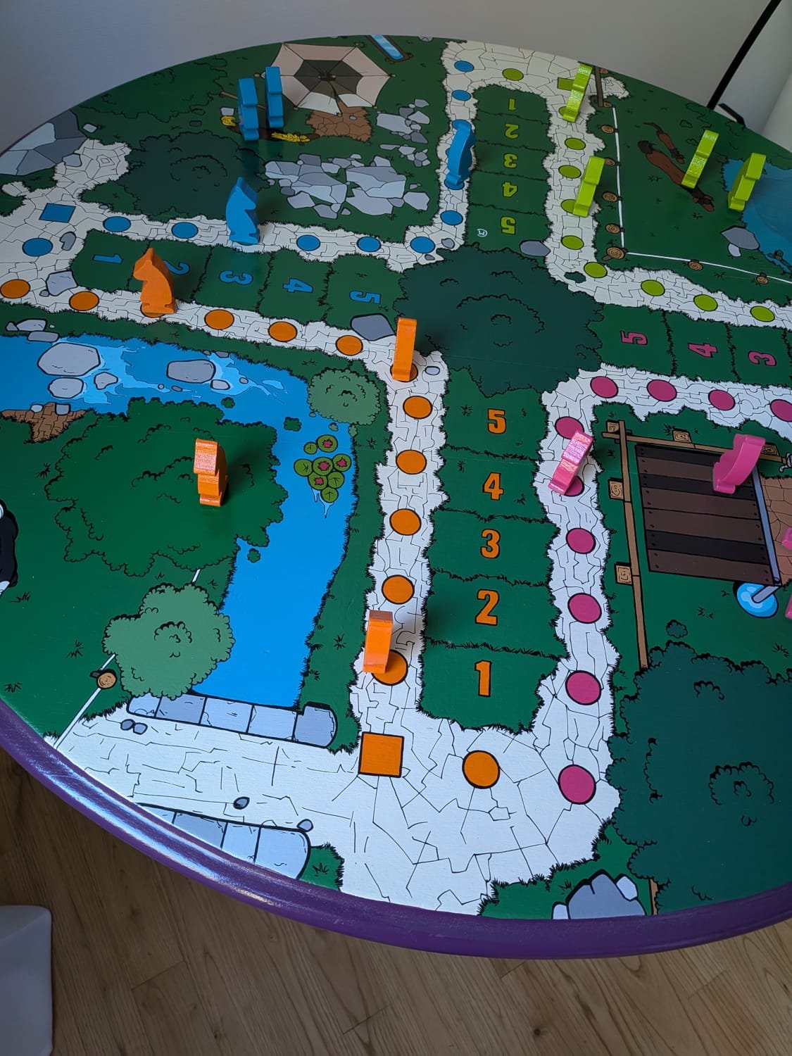 vue de dessus du plateau d'une table en bois représentant un jeu de petit chevaux sur la totalité de la surface